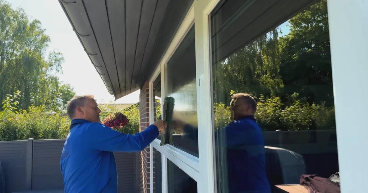 Vinduespolerer fra Madsens Vinduespolering vasker store vinduespartier på et hus